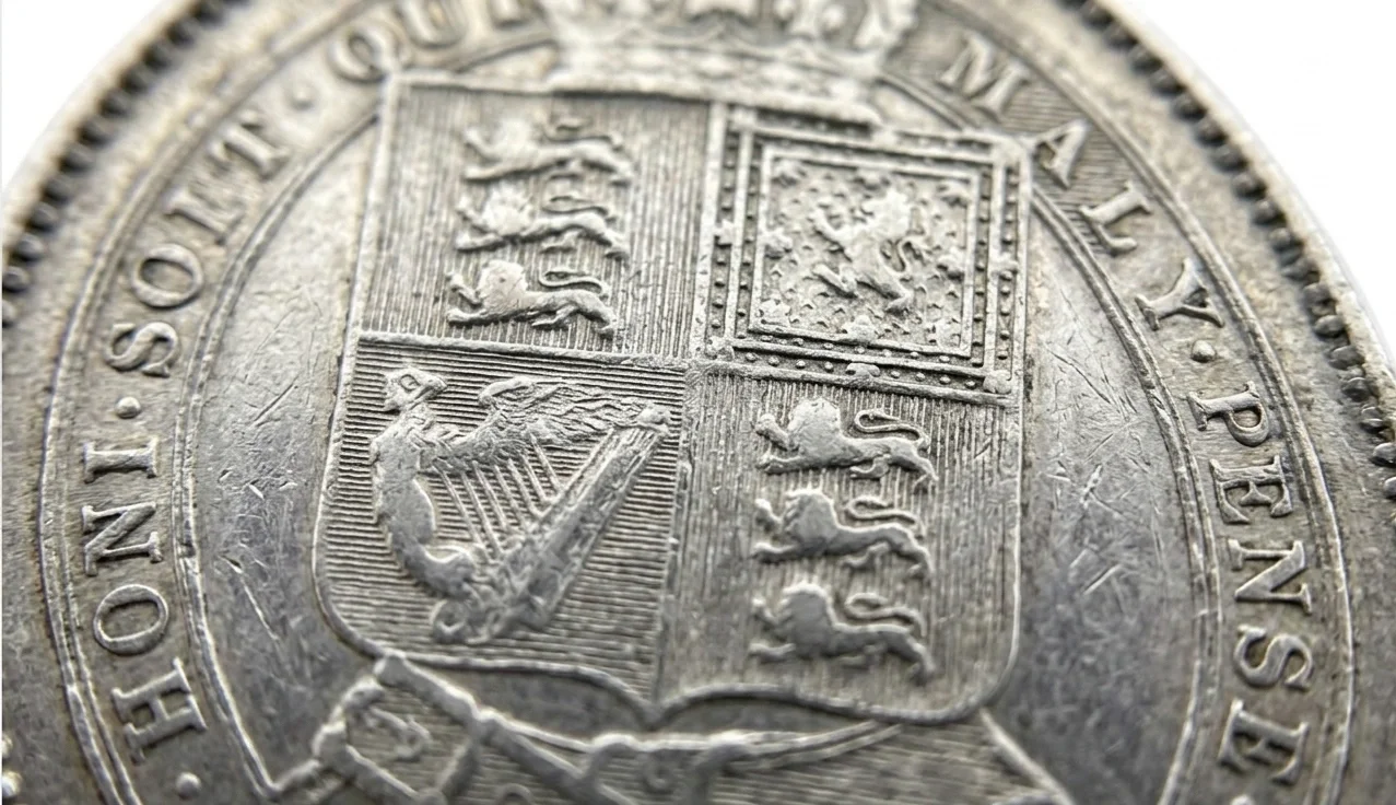 Detailed close-up of a shilling coin highlighting wear patterns